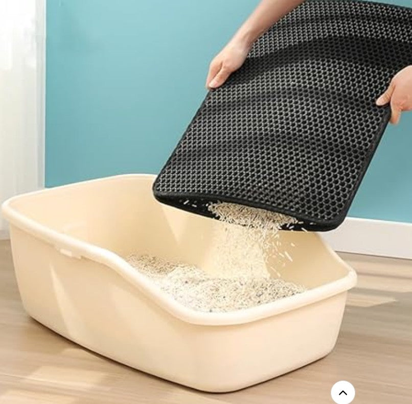 un homme réutilise et vide les grains de litière capturés dans le tapis chat litière  dans le bac litière chat